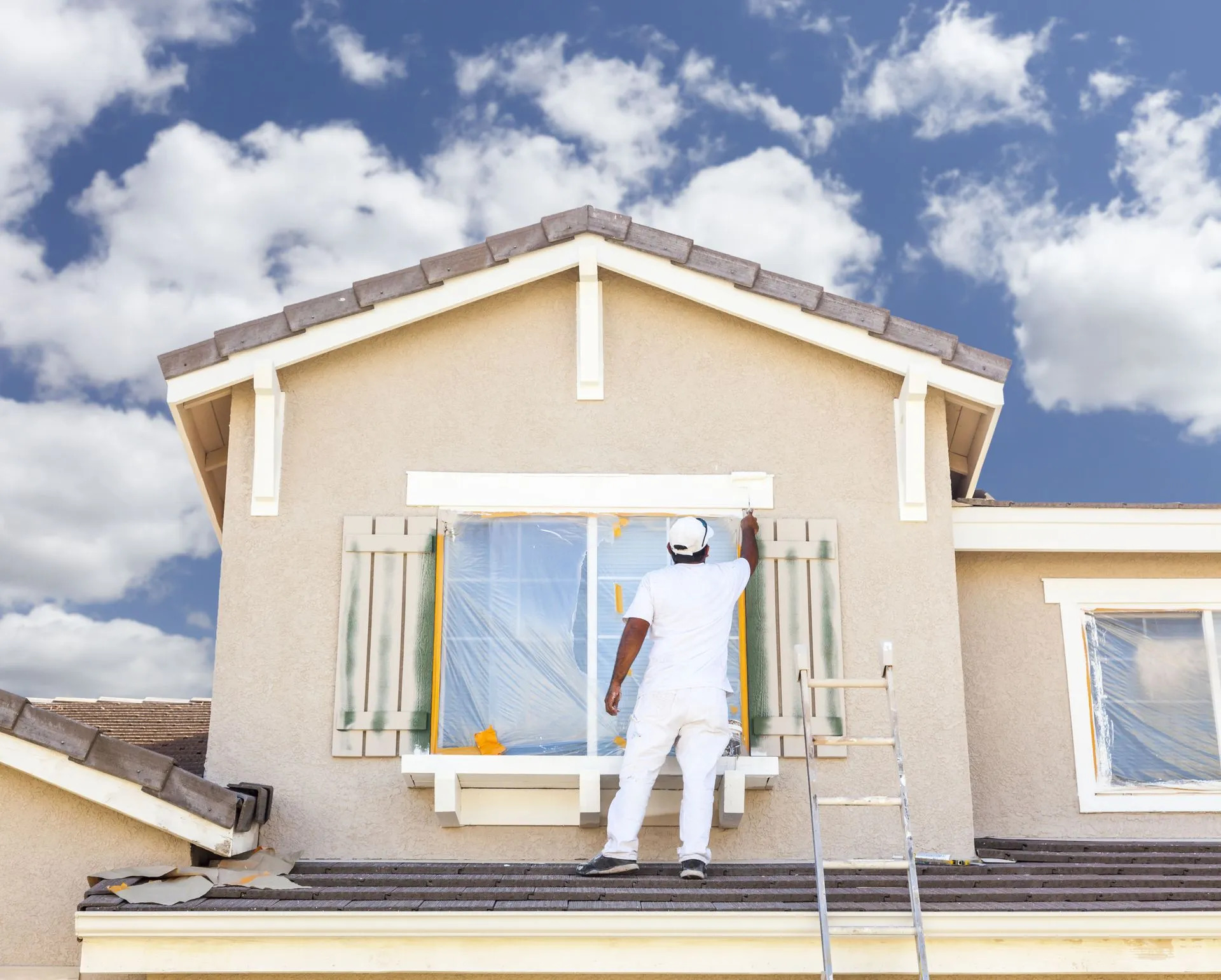 Man working on window on roof of house